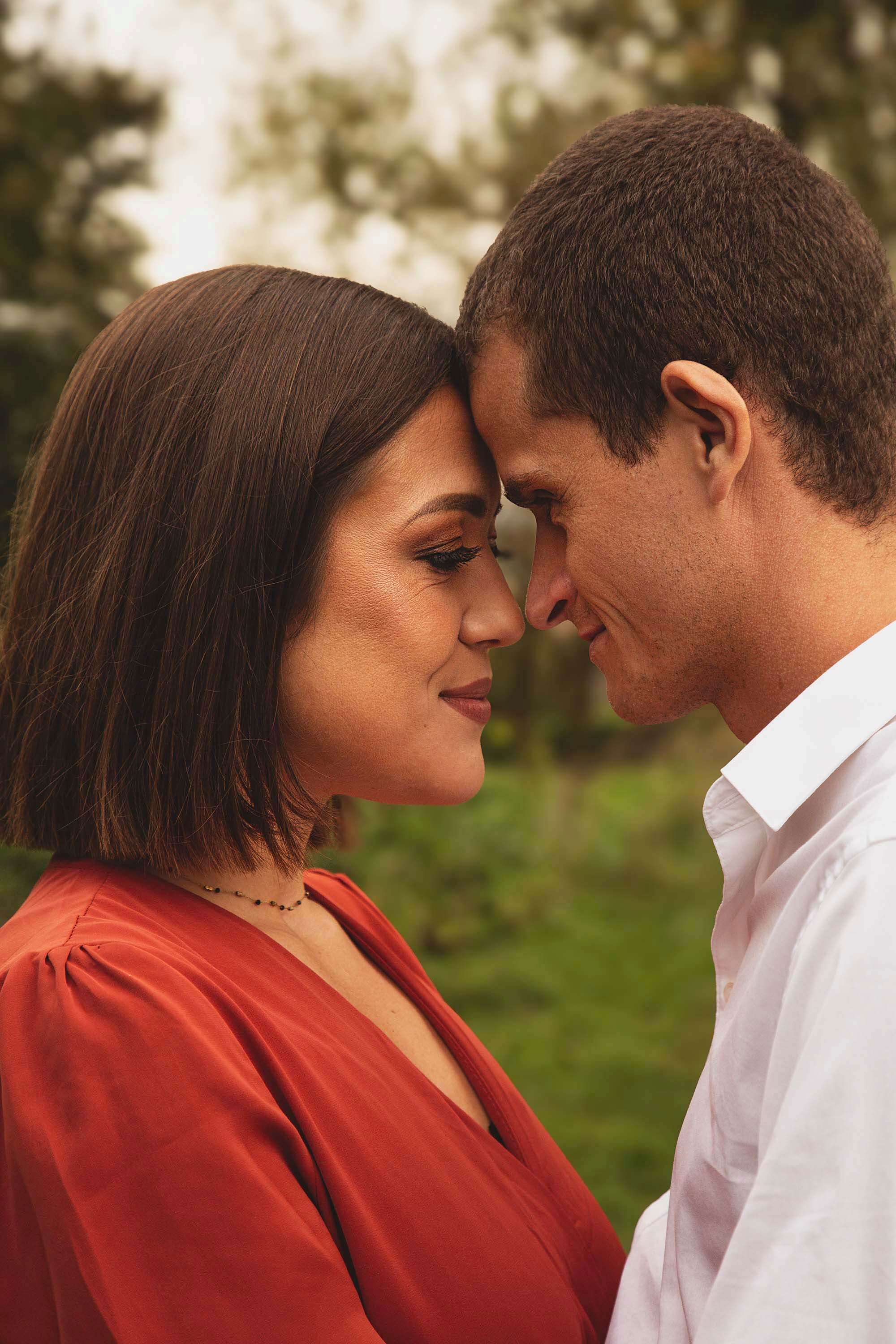 Couple amoureux front contre front en extérieur